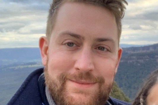 A photo of a man smiling at the camera.