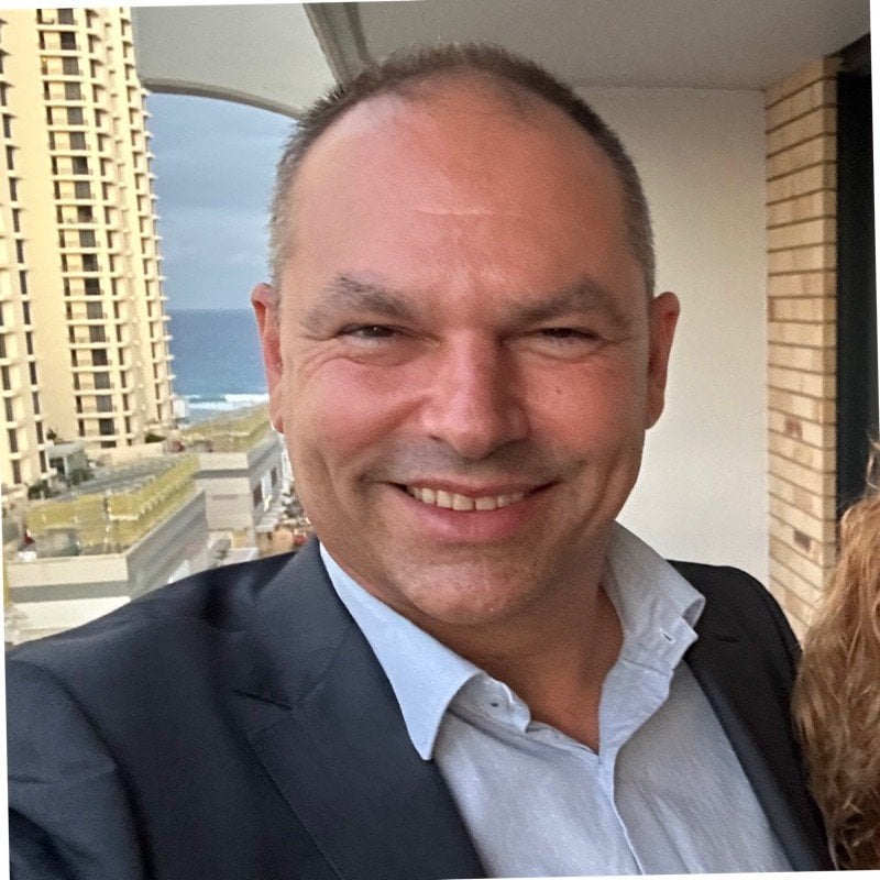 A photo of a man smiling at the camera.