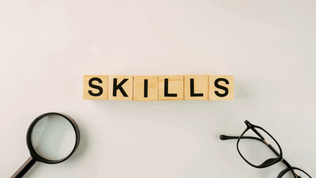 A photo of 6 wood blocks in a row, each with a letter on it. The letters spell out "SKILLS".