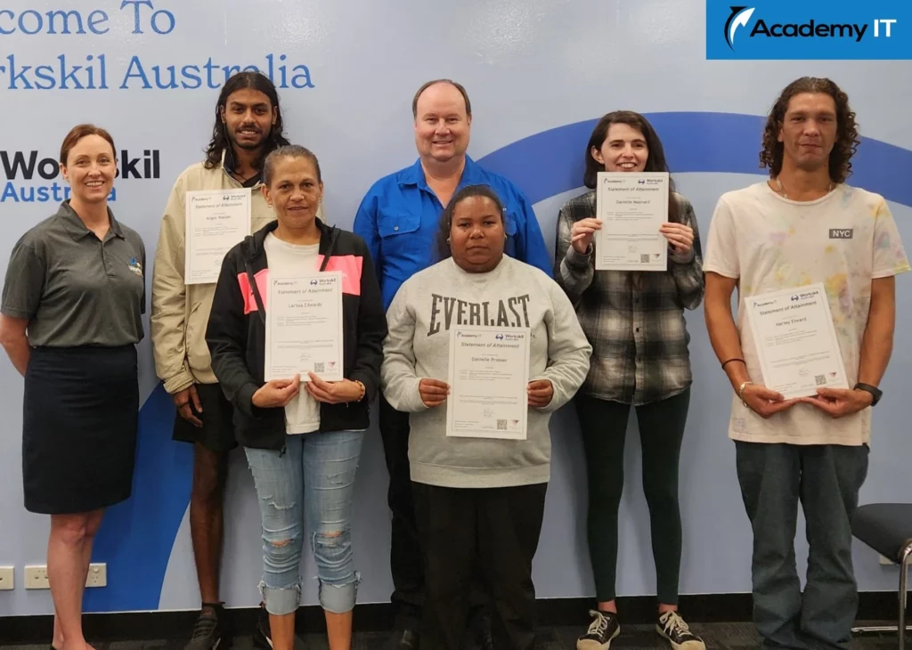 A photo of a group of people smiling at the camera. Some of the people are holding up certificates.