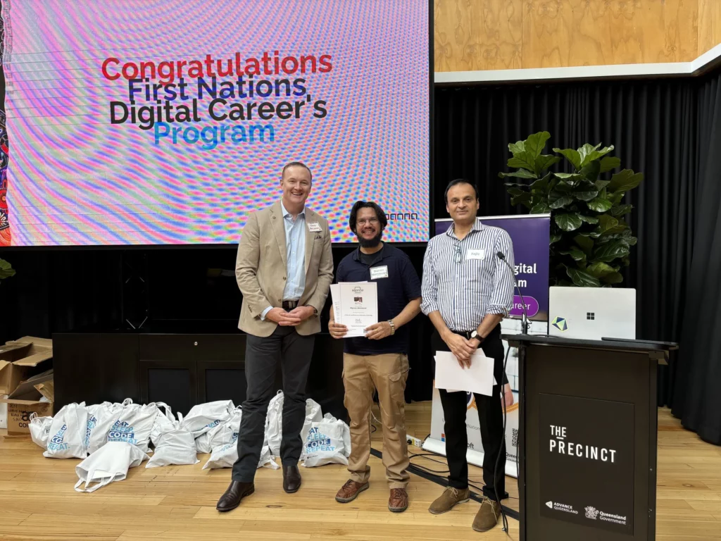 A photo of three people smiling at the camera.