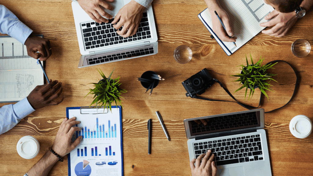 A top-down photo of a group of people working on laptops.